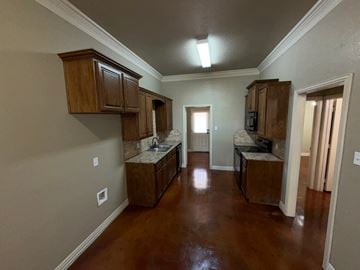 Temple triplex for rent - A kitchen with brown cabinets and a brown floor.