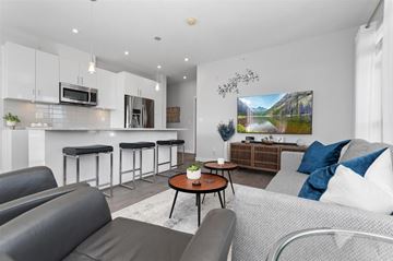 Chilliwack apartment for rent - A modern living room with a grey sofa and a coffee table.