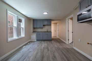 Whiting apartment for rent - A kitchen with a grey countertop and cabinets.