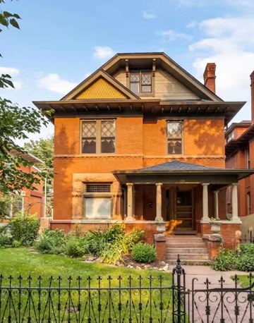 Denver apartment for rent - A Victorian style house with a black iron fence in front.