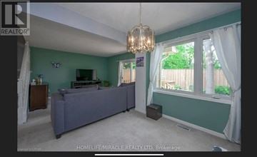 London East (East C) townhouse for rent - A living room with a grey couch and a chandelier.