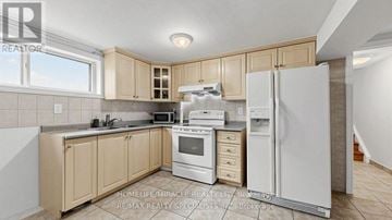 Mississauga (Malton) apartment for rent - A kitchen with wooden cabinets and white appliances.