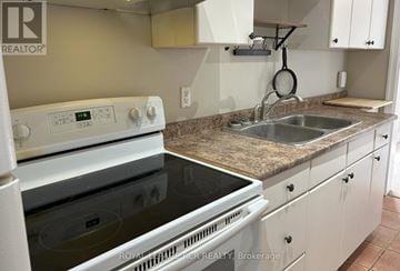 Essa apartment for rent - A white stove and sink in a kitchen.