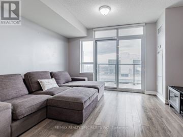 Toronto (Dovercourt-Wallace Emerson-Junction) condo for rent - A living room with a grey couch and a large window.