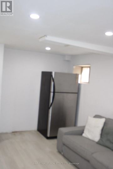 Brampton (Northgate) apartment for rent - A modern living room with a grey couch and a black refrigerator.