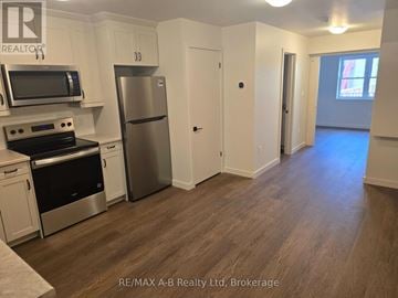 Stratford apartment for rent - A kitchen with white cabinets and a stainless steel refrigerator.