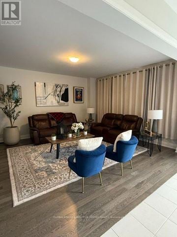 Woodstock (Woodstock - North) apartment for rent - A living room with a brown couch, blue armchair, and a coffee table with a vase of flowers on it.