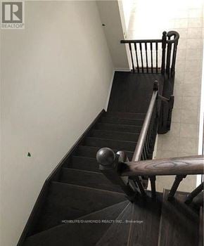 Niagara Falls (Brown) apartment for rent - A staircase with a wooden handrail and steps leading up to a doorway.
