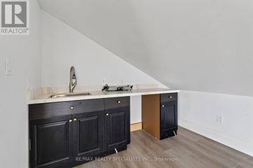 Cramahe apartment for rent - A kitchen with black cabinets and a white countertop.