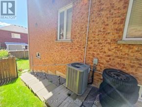 Ajax (Northeast Ajax) apartment for rent - A red brick house with a tire and a heat pump outside.