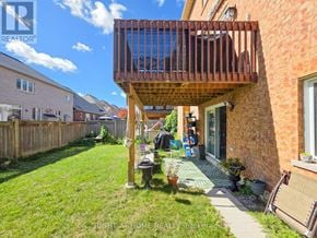 Ajax (Northeast Ajax) apartment for rent - A balcony with a wooden railing and a glass door is attached to a brick house.
