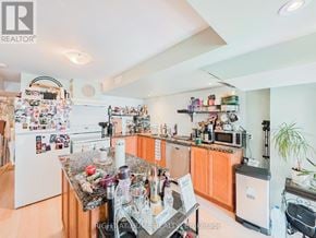 Ajax (Northeast Ajax) apartment for rent - A kitchen with a refrigerator covered in magnets and a counter with a blender on it.