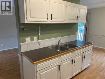 Lethbridge apartment for rent - A kitchen with white cabinets and a dark countertop.
