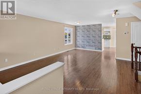 Ottawa townhouse for rent - A spacious room with wooden flooring and a stone wall.