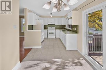 Ottawa townhouse for rent - A well-lit kitchen with white cabinets and a ceiling fan.