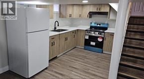 Windsor apartment for rent - A kitchen with a white fridge and wooden floors.