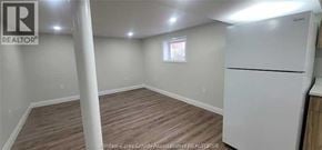 Windsor apartment for rent - A white refrigerator is in a kitchen with wood floors and white walls.