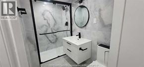 Windsor apartment for rent - A bathroom with a marble wall and a white sink.