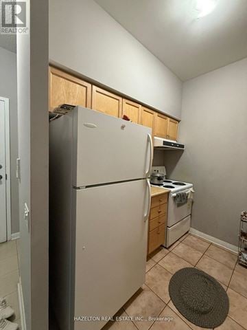 Toronto (Lansing-Westgate) condo for rent - A kitchen with a refrigerator, stove, and cabinets.