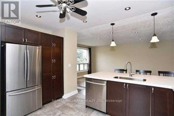 Ajax (South East) apartment for rent - A kitchen with a stainless steel refrigerator and brown cabinets.