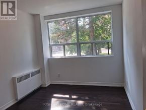 Toronto (Annex) multi-family for rent - A room with a large window and a radiator on the wall.