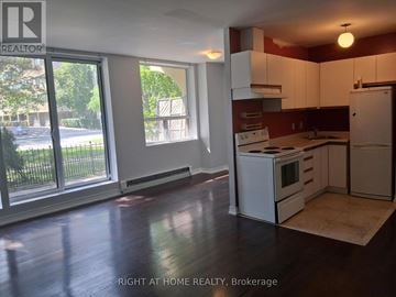 Toronto (Annex) multi-family for rent - A kitchen with white appliances and a large window.