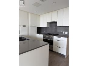 North Vancouver apartment for rent - A modern kitchen with white cabinets and a black countertop.