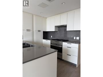 North Vancouver apartment for rent - A modern kitchen with white cabinets and a black countertop.