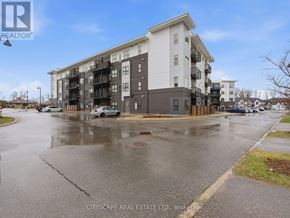 Kitchener condo for rent - A wet street in front of a multi-story apartment building.