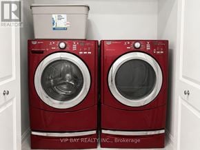 Georgina (Keswick North) apartment for rent - Two red front load washing machines in a laundry room.