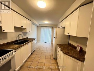 Mississauga (East Credit) townhouse for rent - A kitchen with white cabinets and brown countertops.
