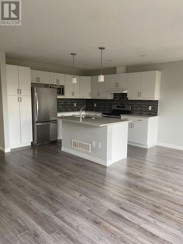 London South (South W) townhouse for rent - A kitchen with white cabinets and a wooden floor.