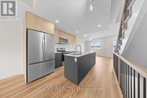 Ottawa townhouse for rent - A modern kitchen with wooden cabinets and a stainless steel refrigerator.
