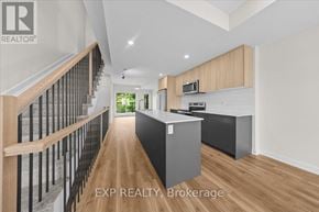 Ottawa townhouse for rent - A modern kitchen with wooden floors and a staircase on the left side.