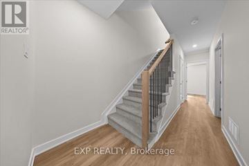 Ottawa townhouse for rent - A hallway with a staircase and a door on the right.