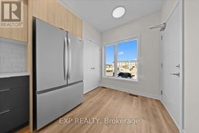 Ottawa townhouse for rent - A kitchen with a refrigerator and a window showing a view of a building.
