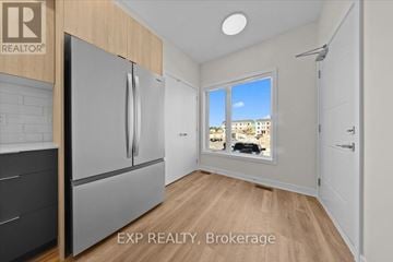 Ottawa townhouse for rent - A kitchen with a refrigerator and a window showing a view of a building.