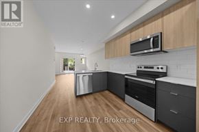 Ottawa townhouse for rent - A kitchen with wooden cabinets and stainless steel appliances.
