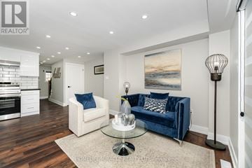 Barrie (Georgian Drive) townhouse for rent - A living room with a blue couch and a glass table.