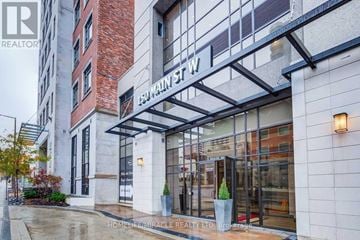 Hamilton (Central) condo for rent - A building with a glass door entrance and a sign that says "Main St W".