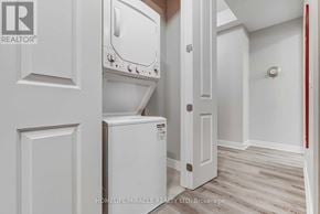 Hamilton (Central) condo for rent - A white washing machine is in a small laundry room.