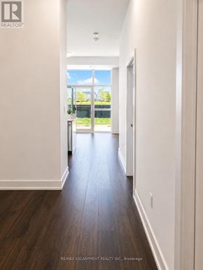 Hamilton (Waterdown) condo for rent - A long hallway with white walls and wood floors.