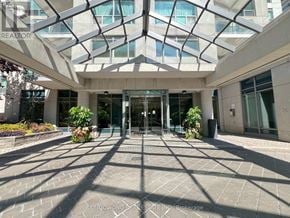 Toronto (Willowdale East) condo for rent - The image shows the entrance to a building with a glass door and a sign that reads "CONDOWONG BEAN ESTATE INC. Brokerage".