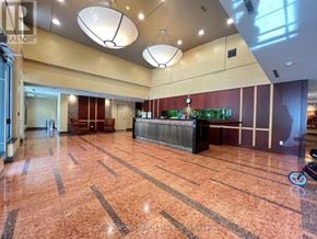 Toronto (Willowdale East) condo for rent - A large, empty lobby with a marble floor and a reception desk.