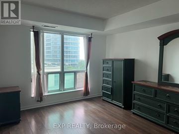 Toronto (Woburn) condo for rent - A room with a large window and wooden floors.