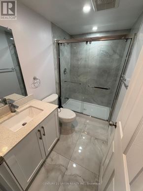Brampton (Bram East) apartment for rent - A bathroom with a glass shower stall and a toilet.