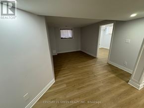 Brampton (Bram East) apartment for rent - A room with wooden flooring and white walls, with a window and a door visible.