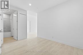 Toronto (Thorncliffe Park) condo for rent - A white room with a wooden floor and a door on the left.