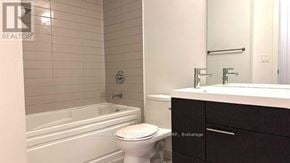 Toronto (Waterfront Communities) condo for rent - A white toilet sits next to a bathtub in a bathroom.