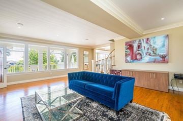 Surrey apartment for rent - A blue sofa sits in a spacious living room with a glass coffee table in front of it.